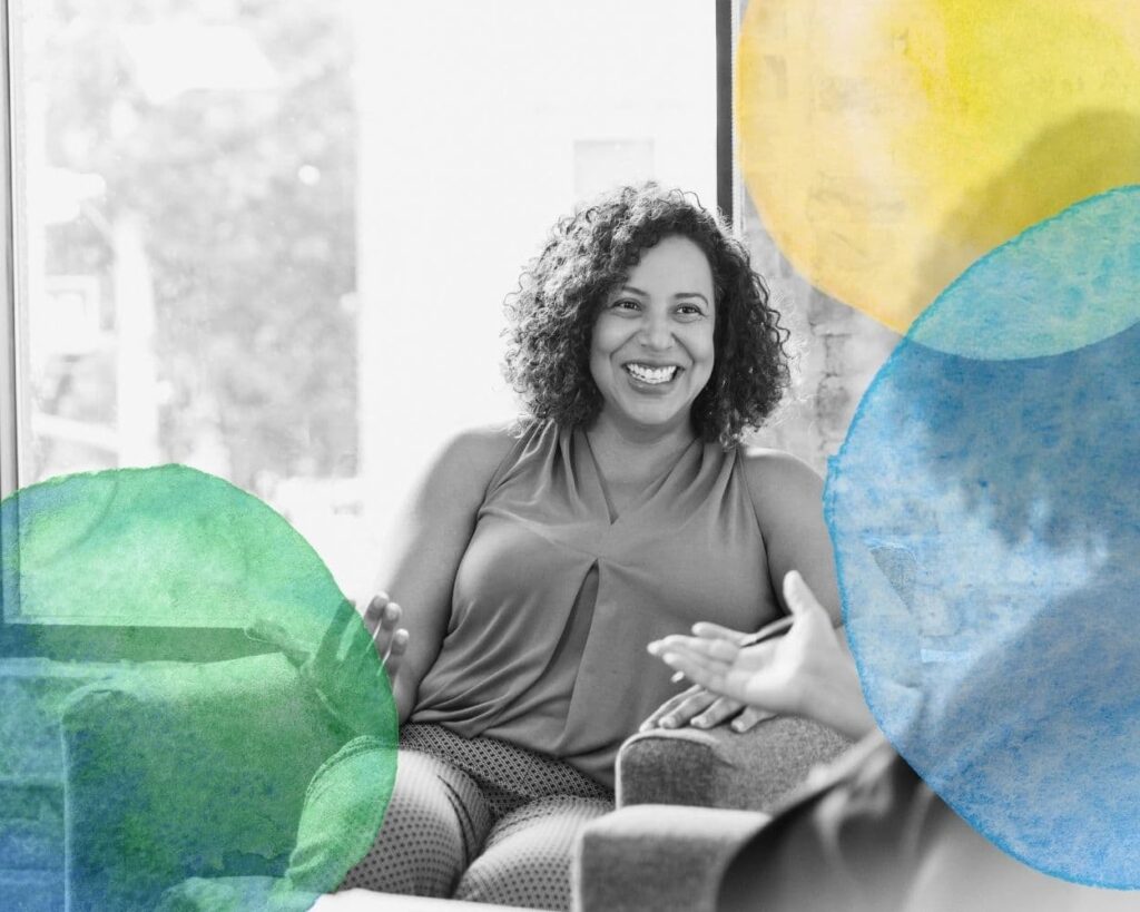 photo d'un jeune femme souriante en conversation avec Malou Tripier, dans un cabinet de sophrologie et d'hypnose à Montbonnot St Martin